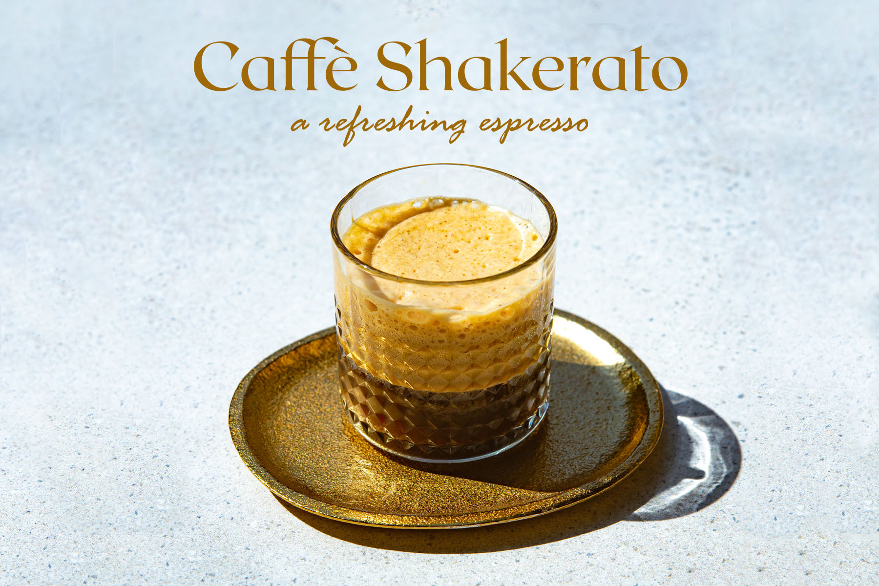 a glass of shakerato coffee on a golden plate on a sunny day
